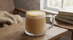 Steaming cappuccino in a glass mug on a wooden table with a cozy background