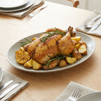 Roasted chicken with potatoes on a plate on a wooden table