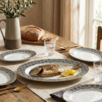 Dining table set with plates, bread, and glasses on a wooden table.