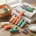 Colorful clothespins on a wooden surface with folded fabric and lavender flowers.