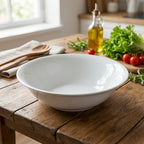 White bowl on a wooden table with fresh vegetables and kitchen utensils in the background