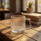Clear glass mug on a wooden table with a blurred indoor background