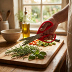 Person using red scissors to trim herbs on a wooden cutting board in a kitchen.