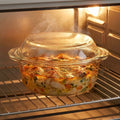 Baked dish in a glass casserole dish with a lid inside an oven.