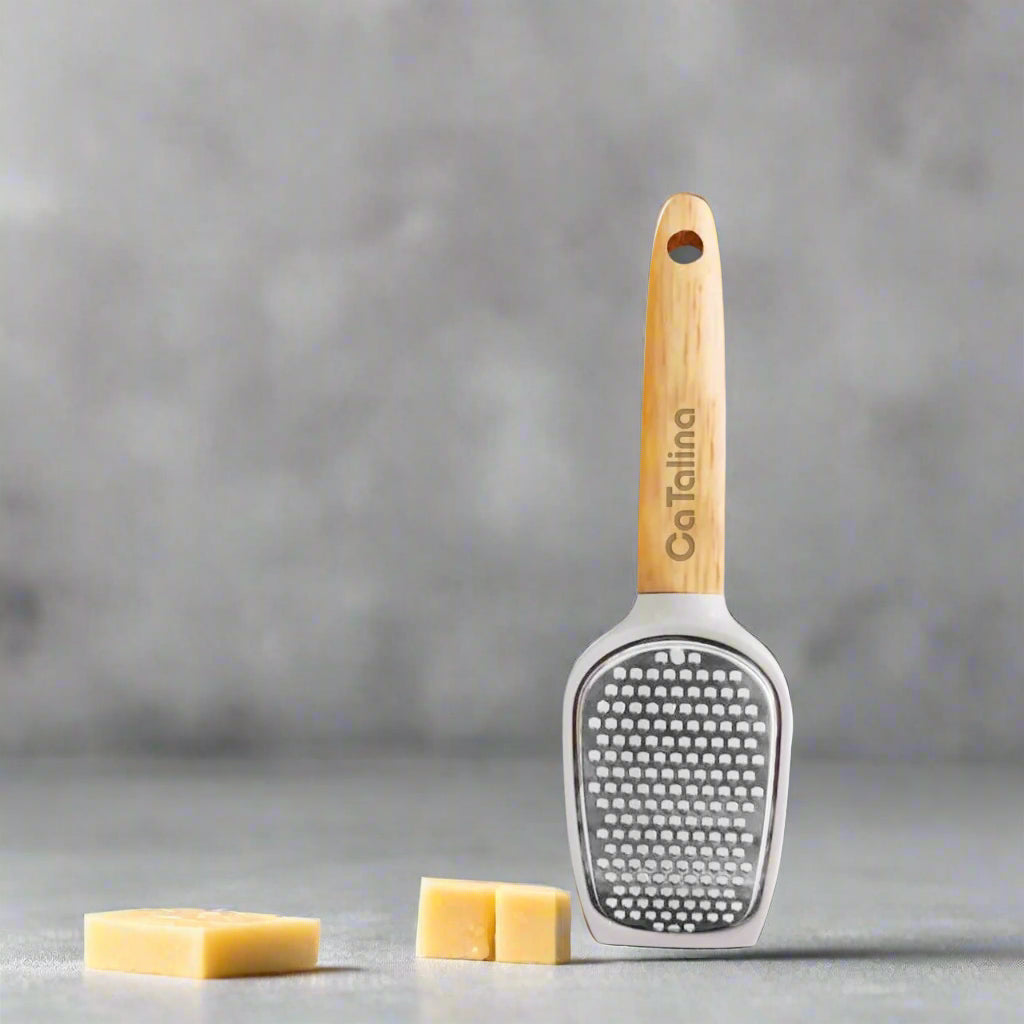 Cheese grater with wooden handle on a gray background